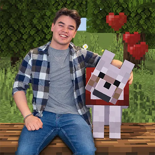 James Deogrades in a flannel shirt, sitting on a Minecraft log, posing with a tamed Minecraft wolf in a pixelated forest.